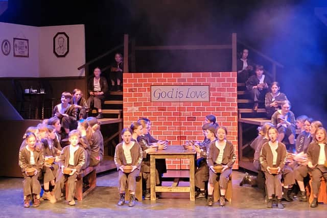 The young ensemble cast of Oliver! singing 'Food Glorious Food'.