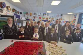Skegnes Academy students and staff with some of the poppies they are donating to the Royal British Legion display. Vice-chairman Tracy Turner (fourth left) went along to receive them.