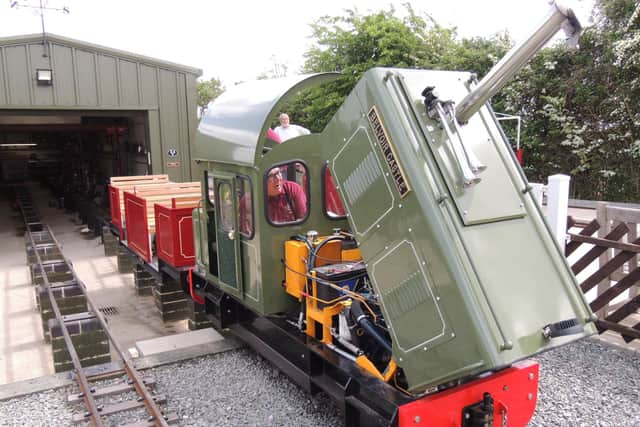 Volunteers making sure Belvoir Castle, the diesel loco, is in good running order. The rails run on raised blocks into the engine shed for easy inspection. ABOVE - friend and volunteer Paul Davidson tests the water for the steam locos. TOP - Glebe Tunnel made from buried motorway drainage pipes with stonework matching Robert's house.