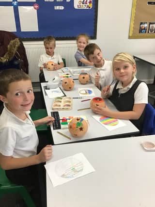 Grimoldby pupils decorating their terracotta candle holders.