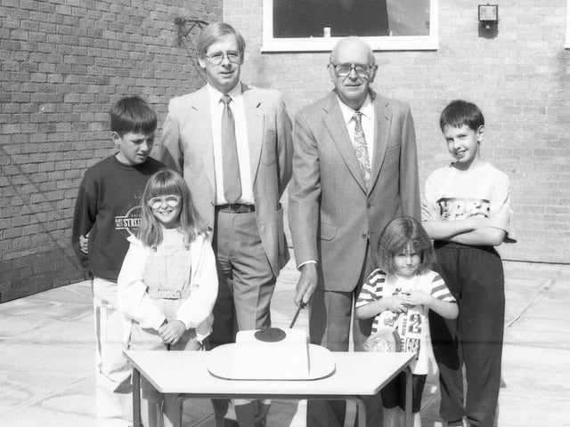 Former headmaster John Ball cuts the school's 25th birthday cake, watched by children and Roy Pearson, the head at the time.