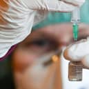 A pharmacist prepares a dose of the Pfizer-BioNTech COVID-19 vaccine. (Photo by HENDRIK SCHMIDT/POOL/AFP via Getty Images)