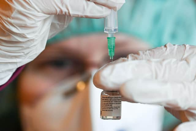 A pharmacist prepares a dose of the Pfizer-BioNTech COVID-19 vaccine. (Photo by HENDRIK SCHMIDT/POOL/AFP via Getty Images)