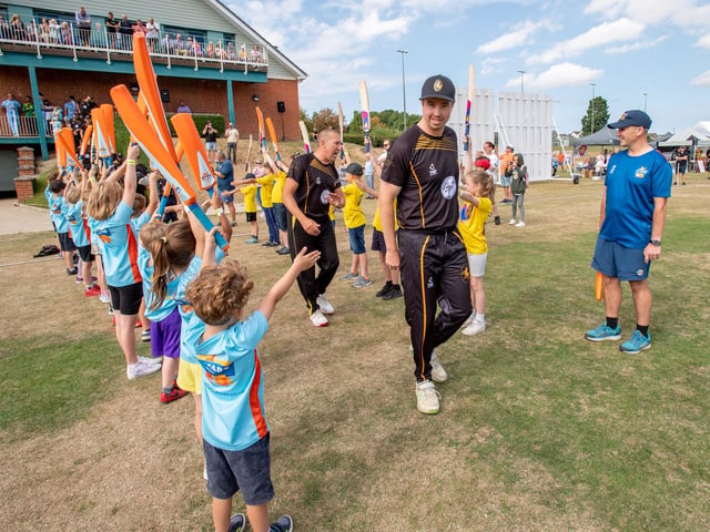 Louth cricket club players are cheered onto the pitch.