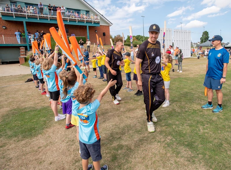 Louth cricket club players are cheered onto the pitch.