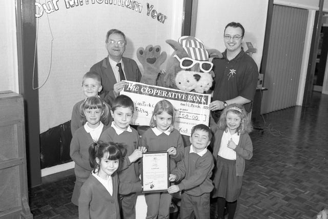 Kool Kat and Mike Baggaley (left) of Lincolnshire Co-op, presenting a £50 cheque to Boston's Park Primary School after it collected five kilos of milk tops for a recycling project. Pictured with the pupils is teacher Stuart Cuthbertson.