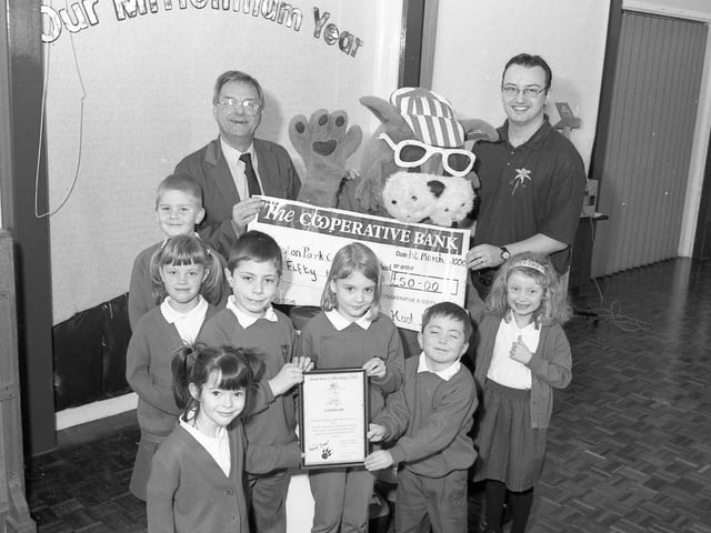 Kool Kat and Mike Baggaley (left) of Lincolnshire Co-op, presenting a £50 cheque to Boston's Park Primary School after it collected five kilos of milk tops for a recycling project. Pictured with the pupils is teacher Stuart Cuthbertson.
