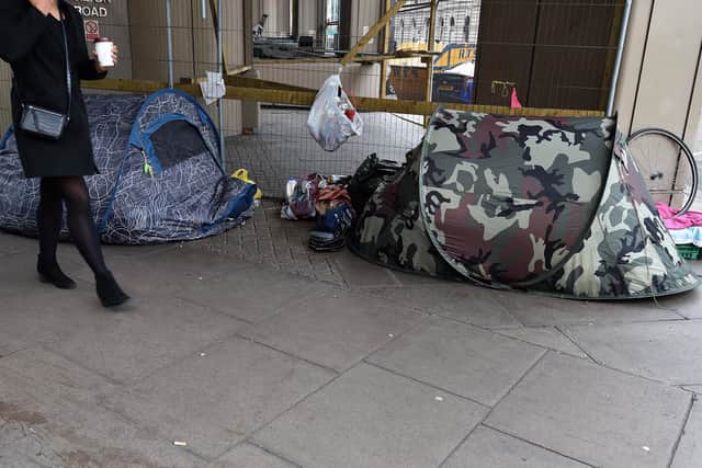 A woman walks past tents of the homeless in Victoria, London. PA Photo. Picture date: Thursday January 16, 2020. Photo credit should read: Nick Ansell/PA Wire