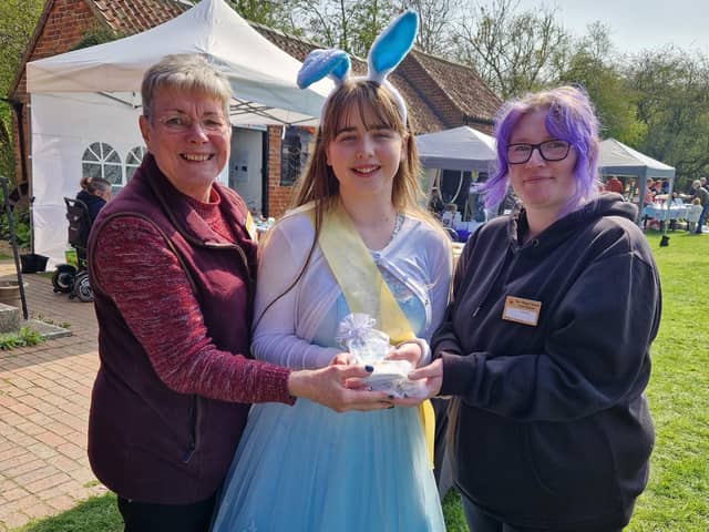 Summer Willetts presents a cheque for more than £1,000 to (from left) assistant manager and volunteer  Maxeen Andrew and manager Naomi Walton.