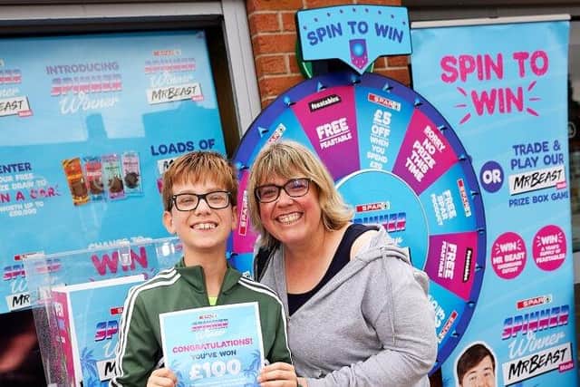 Anna Black wins £100 on the Spar spin game in Sleaford, with son Angus, 12.
