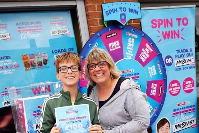 Anna Black wins £100 on the Spar spin game in Sleaford, with son Angus, 12.