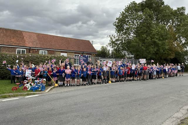 Utterby school children turn out to cheer on the cyclists.
