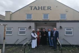 Leader of North Lincolnshire Council, Coun Rob Waltham (far right) and Scunthorpe MP Holly Mumby-Croft (centre) pictured with members of The Bangladesh Welfare Association North Lincolnshire outside the building on Ferry Road that is set to be transformed. Image: North Lincolnshire Council