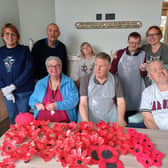 Members of The Old Statin Group with the pile of poppies they have already created. Image: Dianne Tuckett