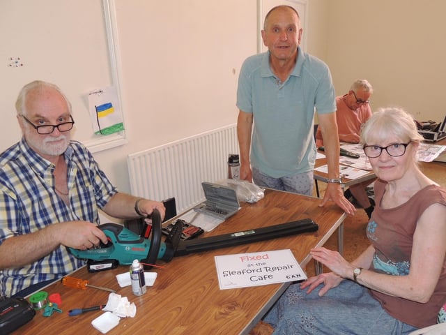 Colin Spencer fixes a faulty switch on the hedge trimmers brought in by Charmian Morgan, of Cranwell, watched by Tim Grigg.