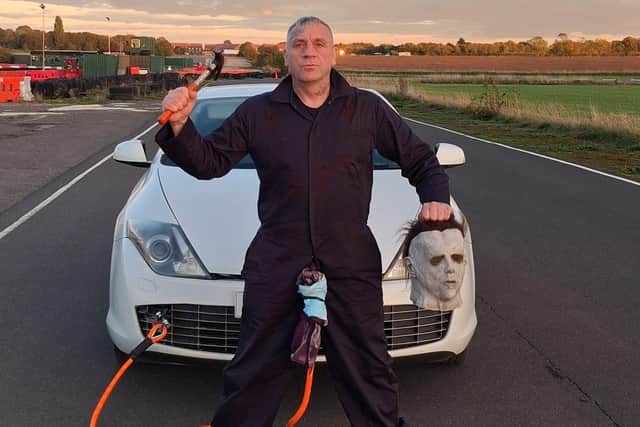 John Stephenson dressed as Halloween villain Michael Myers with the Renault Laguna Coupe, which he pulled using the end of his penis in strongman stunt. Photo: Jane Pumphrey / SWNS