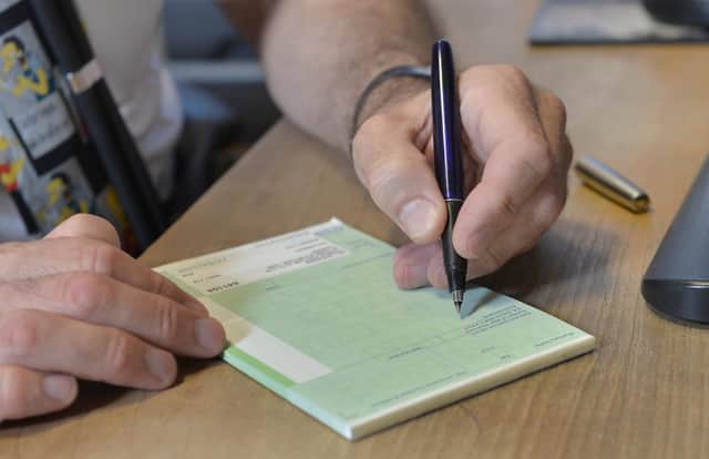 Dr Laurence Buckman writes a prescription in his practice room at the Temple Fortune Health Centre GP Practice near Golders Green, London.