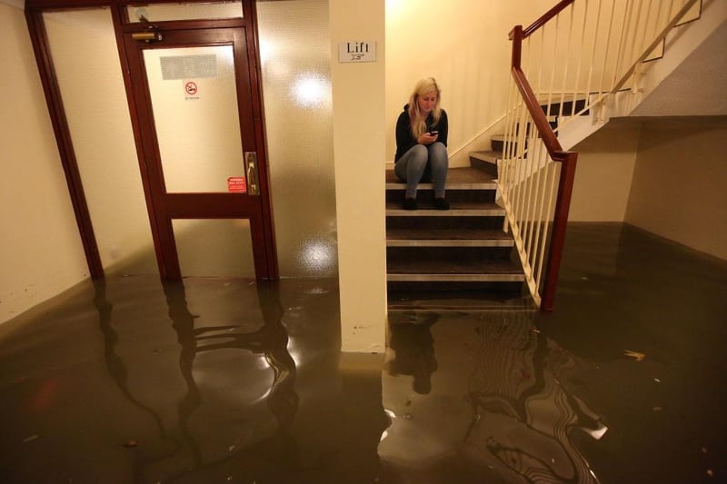 A resident sits on the stairs of an apartment deep in flood water on December 5, 2013 in Boston, England. (Photo by Peter Macdiarmid/Getty Images)