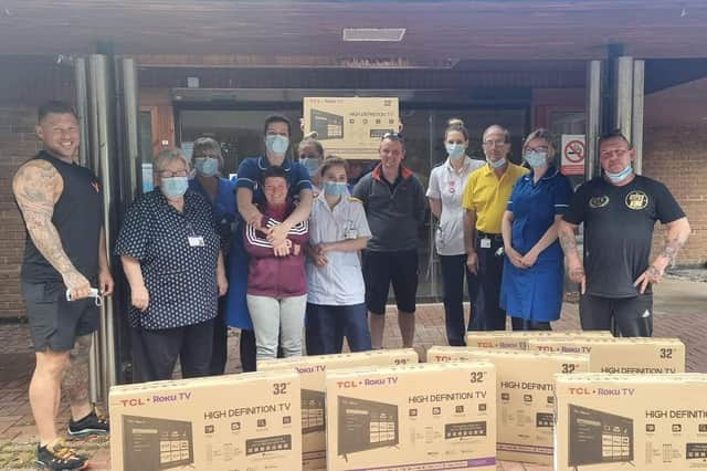 PCSO Michelle Collins (third from left) delivering televisions with Jack from the Phoenix Gym (left) and Andy from Giff Gaff (right) to staff at the Bostonian.