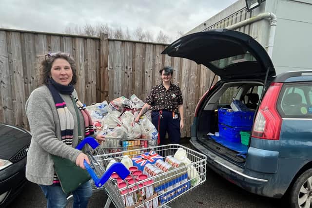The larder's Isabel Forrester loads the donations from Tesco's with manager Jess Smith.