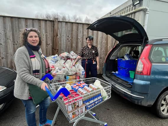 The larder's Isabel Forrester loads the donations from Tesco's with manager Jess Smith.