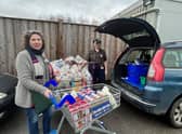 The larder's Isabel Forrester loads the donations from Tesco's with manager Jess Smith.