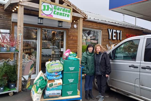 Laura (left), from JJ's Garden Centre and Independent Pet Store, of Woodhall Spa, hands over more than £300 worth of Natures Menu dog-food to Jane, one of the volunteers at Fen Bank Greyhound Sanctuary.