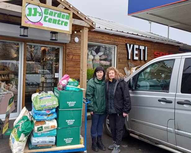 Laura (left), from JJ's Garden Centre and Independent Pet Store, of Woodhall Spa, hands over more than £300 worth of Natures Menu dog-food to Jane, one of the volunteers at Fen Bank Greyhound Sanctuary.