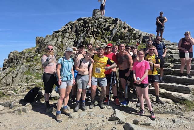 On top of the world - Sean Booth, pictured with his team,  after climbing  the three highest peaks in the UK on one leg  - in just three days.