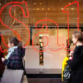 Pedestrians pass a store advertising sales discounts. Picture: Frantzesco Kangaris/Bloomberg via Getty Images.