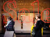 Pedestrians pass a store advertising sales discounts. Picture: Frantzesco Kangaris/Bloomberg via Getty Images.