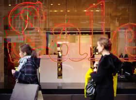 Pedestrians pass a store advertising sales discounts. Picture: Frantzesco Kangaris/Bloomberg via Getty Images.