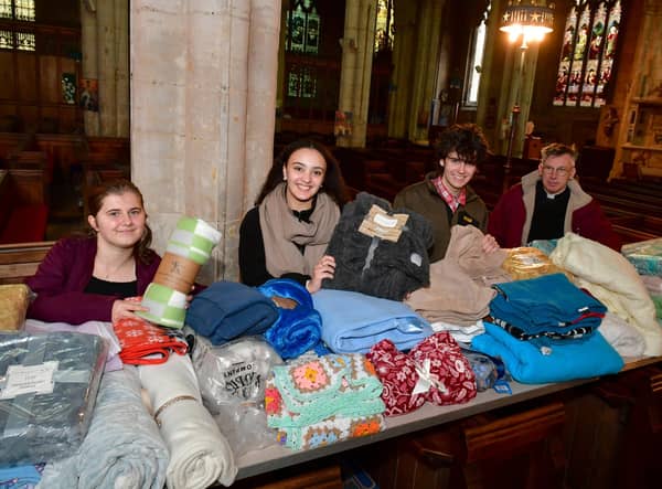 St George's Academy students giving out free blankets and coffee at St Deny's Church on Saturday. From left - Jessica Annan 18, Ranya Tran 18, Ellis Jackson 17, with Rev Philip Johnson.
