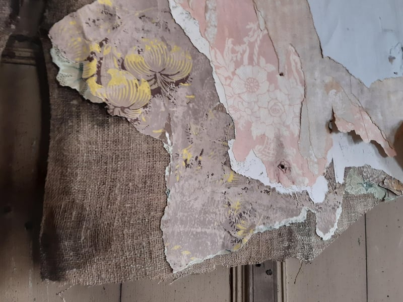 The layers of wallpaper and Hessian that hid the oak-panelled office.