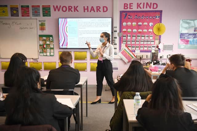 Children and the teacher wearing facemasks during a lesson at Hounslow Kingsley Academy in West London, as pupils in England return to school for the first time in two months as part of the first stage of lockdown easing. Picture date: Monday March 8, 2021.
