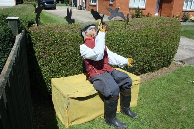 A curious 'farmer' scarecrow stops to take a drink in Friskney.