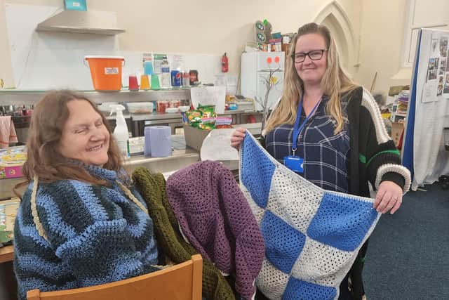 Sharon Ord showing Jodi the lap blankets she has made to help people keep warm this winter.