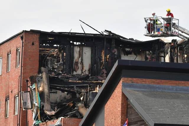 The fire service pictured assessing the damage at the four-storey building.