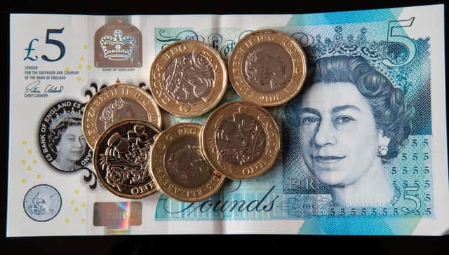 New 12-sided &pound;1 coins on a new &pound;5 note in Liverpool as the new pound coin entered circulation - with early teething problems expected at coin-operated machines across the country.