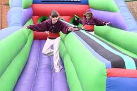 L-R Maddie Musgrove 9 and Tillie Musgrove 9 of Scopwick take on the bungee run inflatable at Metheringham Fayre and feast.