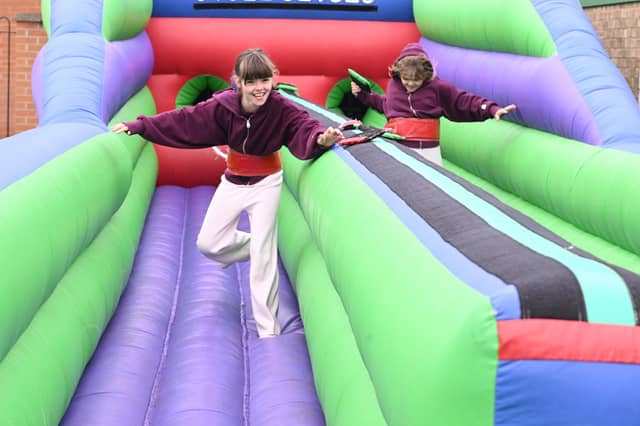 L-R Maddie Musgrove 9 and Tillie Musgrove 9 of Scopwick take on the bungee run inflatable at Metheringham Fayre and feast.