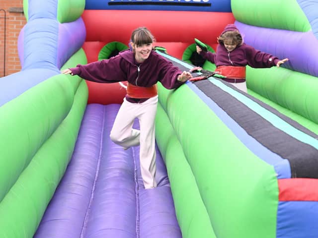 L-R Maddie Musgrove 9 and Tillie Musgrove 9 of Scopwick take on the bungee run inflatable at Metheringham Fayre and feast.