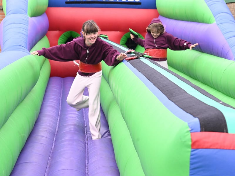 L-R Maddie Musgrove 9 and Tillie Musgrove 9 of Scopwick take on the bungee run inflatable at Metheringham Fayre and feast.