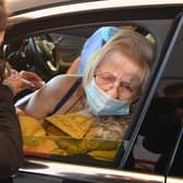 Joan Burgess receives an injection of her first dose of the Pfizer-BioNTech Covid-19 vaccine in her car at a drive-in vaccination centre in Hyde, Greater Manchester (Photo by OLI SCARFF/AFP via Getty Images)