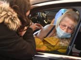 Joan Burgess receives an injection of her first dose of the Pfizer-BioNTech Covid-19 vaccine in her car at a drive-in vaccination centre in Hyde, Greater Manchester (Photo by OLI SCARFF/AFP via Getty Images)