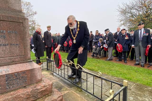 Mayor Cllr Steven Holland lays a wreath at the base of the War Memorial.