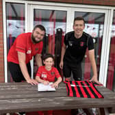 Woodhall Spa United U9's head coach Dan Howitt (left) and assistant coach Tom Bell signing contracts with players.