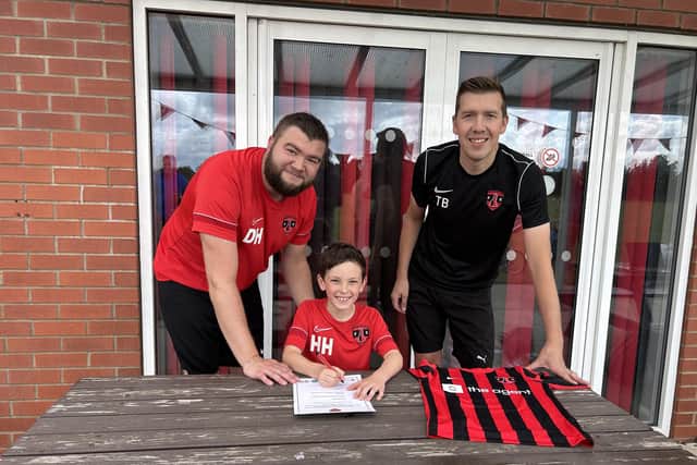 Woodhall Spa United U9's head coach Dan Howitt (left) and assistant coach Tom Bell signing contracts with players.