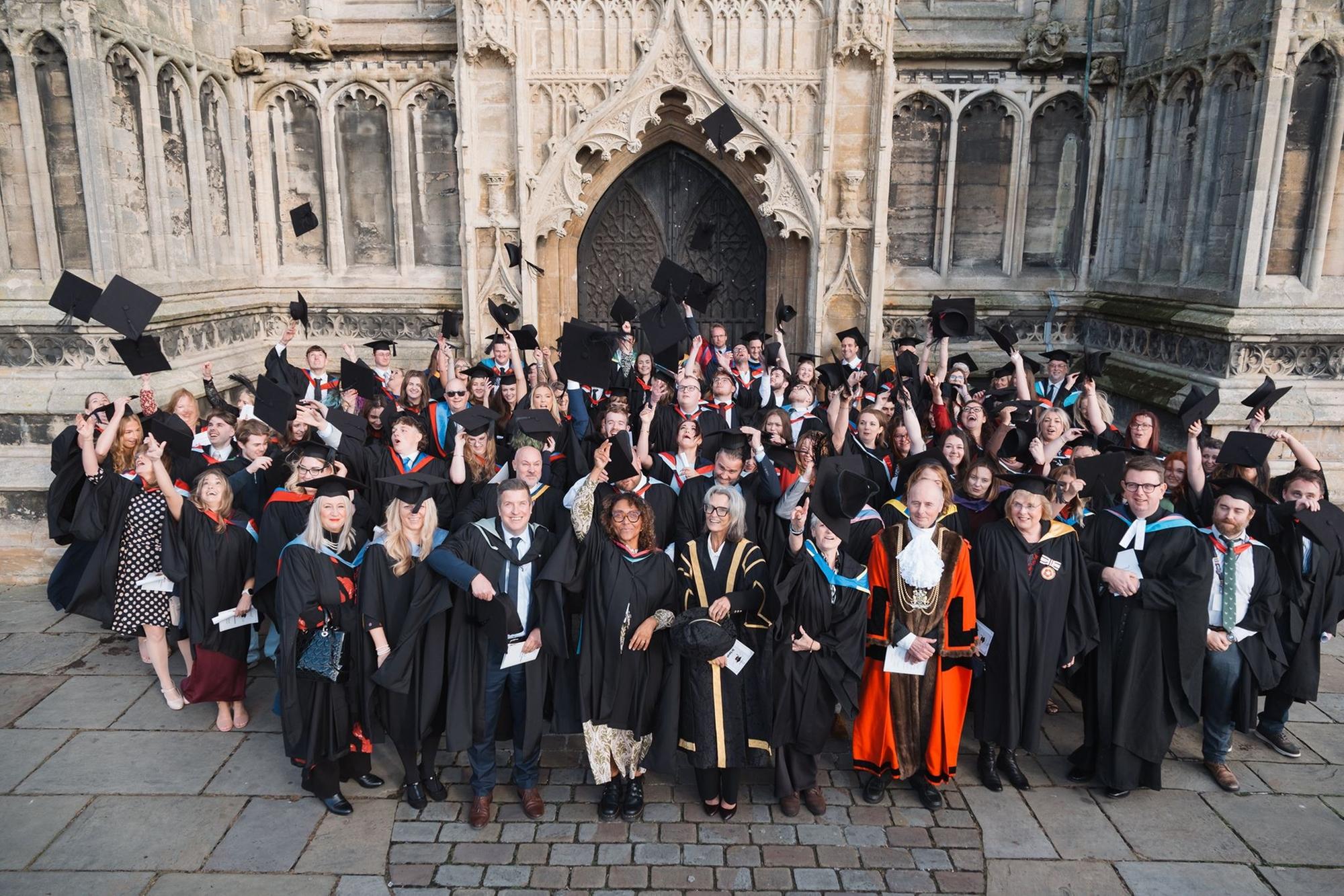 Mortarboards take flight outside St Botolph's Church at Boston College's Higher Education Graduation Ceremony.