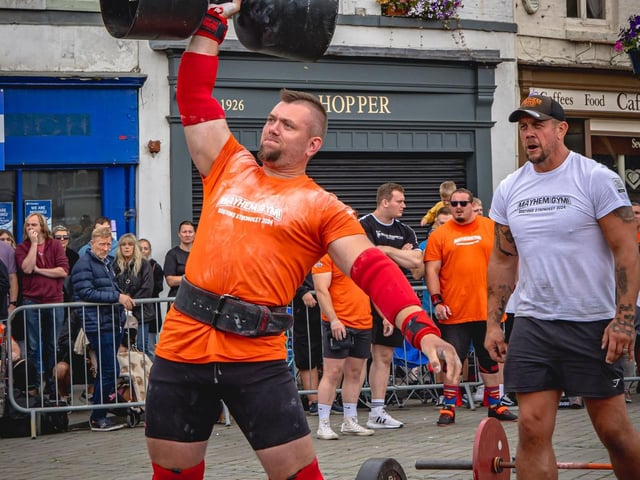 Ramunas Domkus, of Boston, overhead pressing a monster dumbbell.
